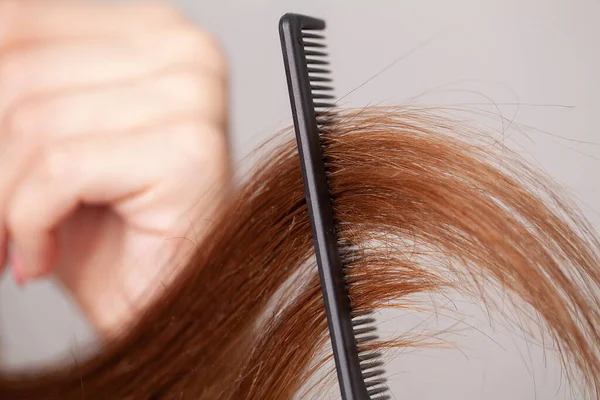 Taraklı ve beyaz arka planda saçları olan bir kadın.