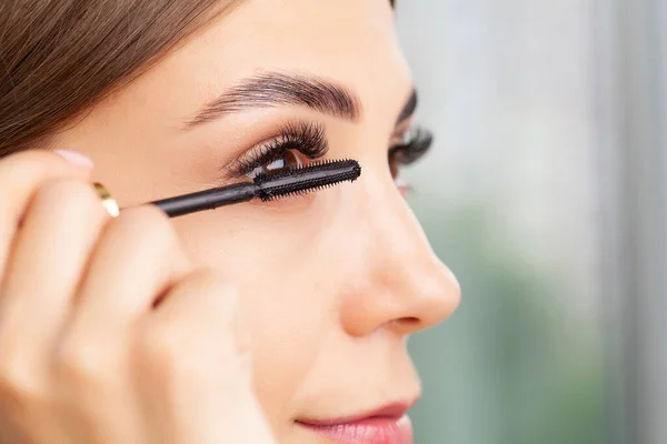 Hermosa joven haciendo maquillaje en su cuarto de baño. —  Fotos de Stock