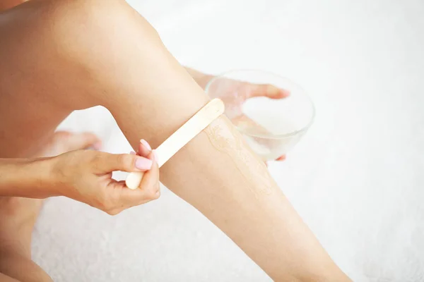 Młoda kobieta depilująca nogi płynnym cukrem w domu — Zdjęcie stockowe