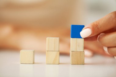 Kadınlar elleriyle merdiven şeklinde tahta bloklar koyarlar.