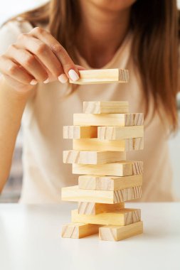 Genç bir iş kadınının eli Strateji ve planlama projesiyle odun bloğu oyunu oynayacak