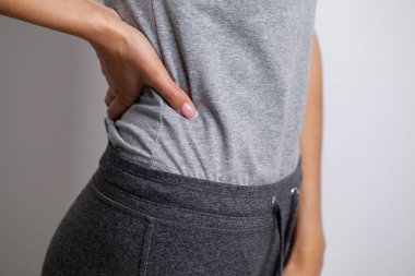 Acı çeken genç bir kadın filetoya dokunuyor.