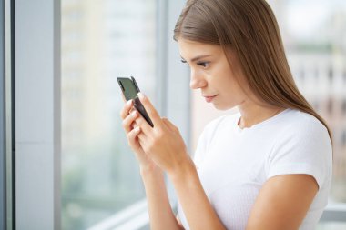 Akıllı telefonu ve sosyal ağlarıyla kafayı bozmuş güzel bir kadın.