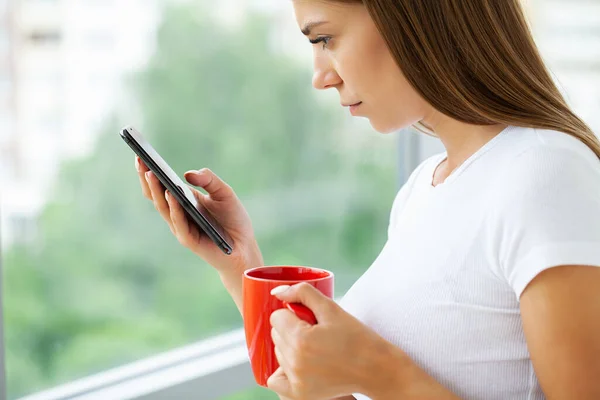 Söt ung kvinna besatt av sin smartphone och sociala nätverk — Stockfoto