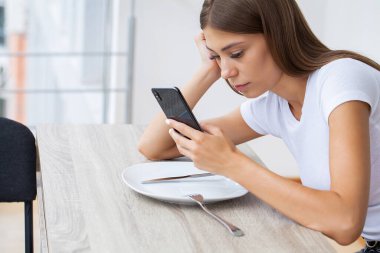 Akıllı telefonu ve sosyal ağlarıyla kafayı bozmuş güzel bir genç kadın.