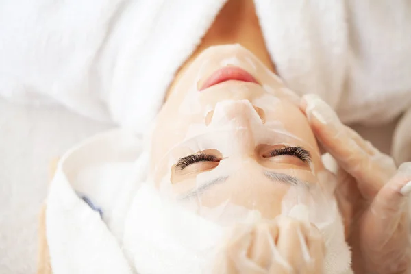 Beautiful young woman use sheet facial mask on face skin for beauty spa — Stock Photo, Image