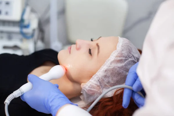 Mujer recibiendo masaje facial ultrasónico en máquina de ultrasonido facial. — Foto de Stock