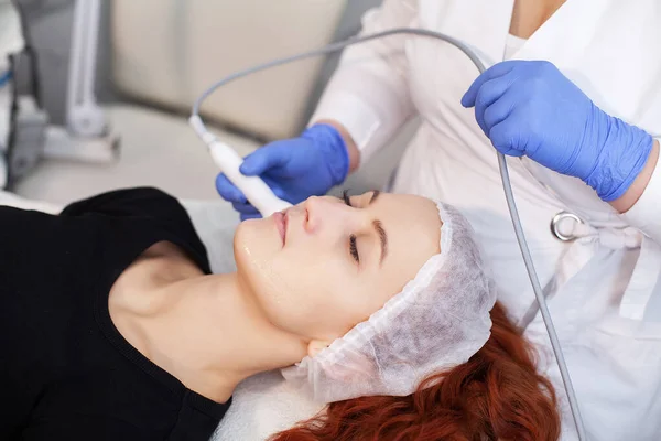 Mujer recibiendo masaje facial ultrasónico en máquina de ultrasonido facial. — Foto de Stock
