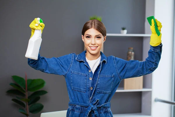Portret van een gelukkig jong dienstmeisje met schoonmaakspullen — Stockfoto