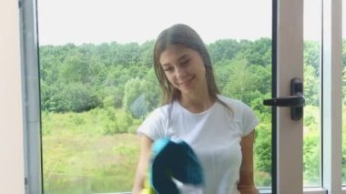 Modern ofiste pencere temizleyen genç bir kadın..