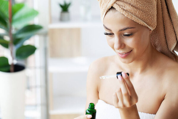 Милая молодая леди делает ежедневные утренние процедуры по уходу за кожей.