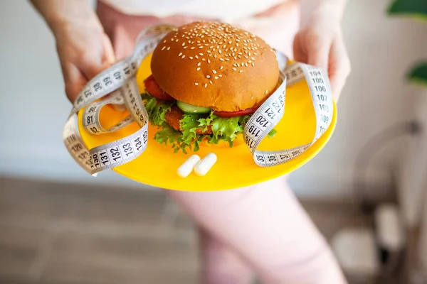 Femme Tenant Burger Gras Nocif Avec Ruban Mesurer Blanc — Photo