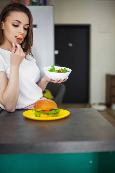 Piękna Młoda Kobieta Decyduje Się Jeść Hamburgera Lub Świeżą Sałatkę — Zdjęcie stockowe