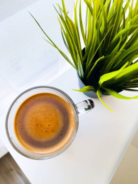 Beyaz masadaki kahve ofiste kırılma olduğunu gösteriyor..