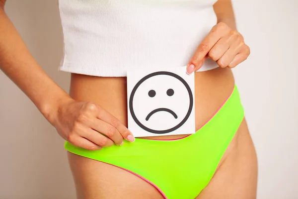 Woman Health, Female Body In Bikini Holding Sad Smile Card Near Stomach, Woman health problem and menstruation pain.