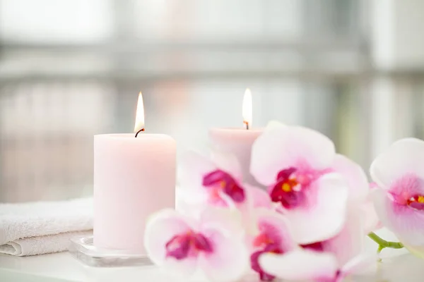 Orchids and burning aromatic candles on spa salon.