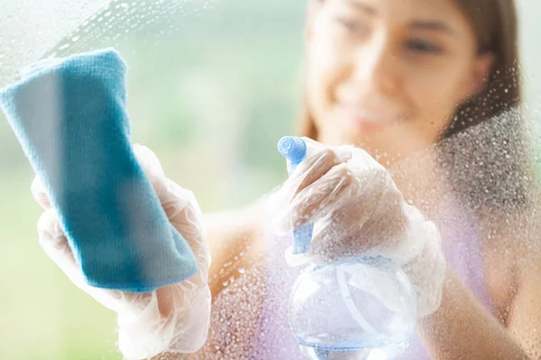 Young Smiling Woman Washing Window with Sponge