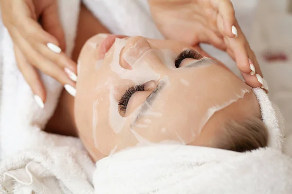 Young woman with cloth mask at spa salon.