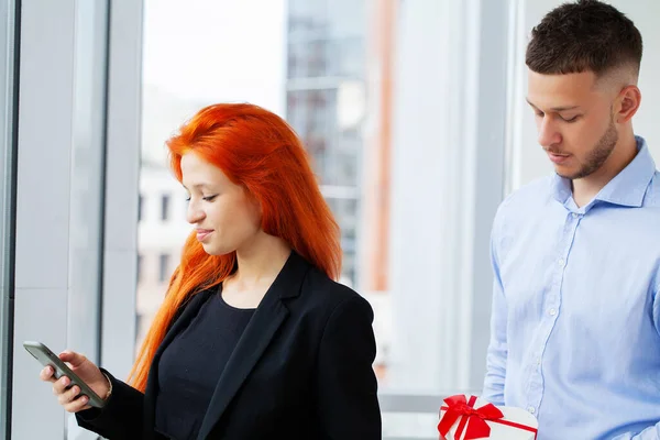 Couple working together at small office with laptop and documents.