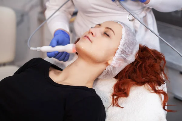 Woman at electro stimulation therapy in cosmetic clinic.