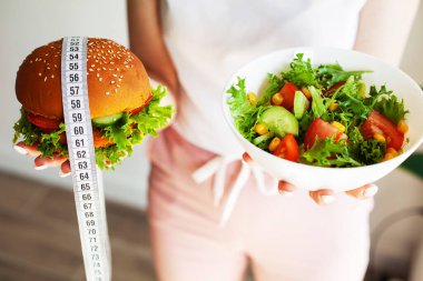 Kadın mutfakta hamburger ya da taze salata yemeye karar veriyor..