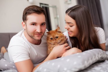 Mutlu, şehvetli, genç çift yatakta birlikte yatıyor..