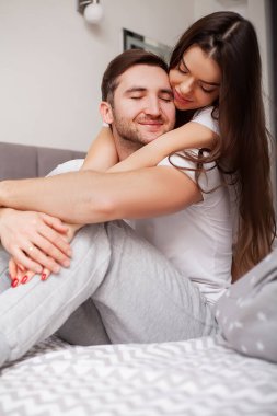 Mutlu, şehvetli, genç çift yatakta birlikte yatıyor..