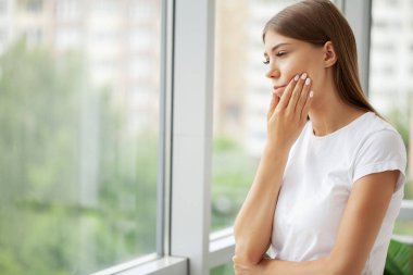 Ofiste çalışırken dişleri ağrıyan bir kadın.