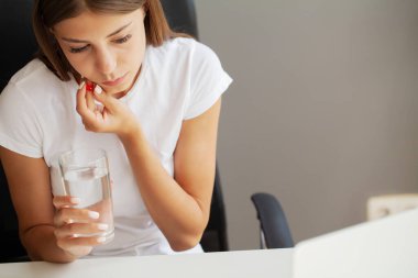 Ofiste çalışırken dişleri ağrıyan bir kadın.