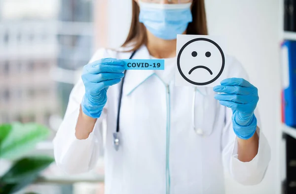 Médico Sostiene Una Tarjeta Con Símbolo Sonrisa Triste Oficina Clínica — Foto de Stock