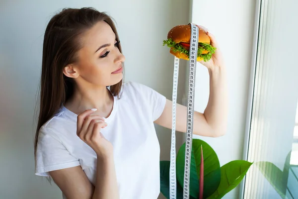 Kobieta Burgerem Taśmą Pomiarową Podczas Diety — Zdjęcie stockowe