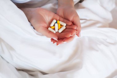 Bir dişinin avucunda çok farklı tipte haplar var..