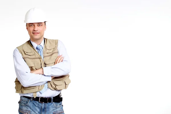Улыбчивый человек, работающий в строительной каске — стоковое фото