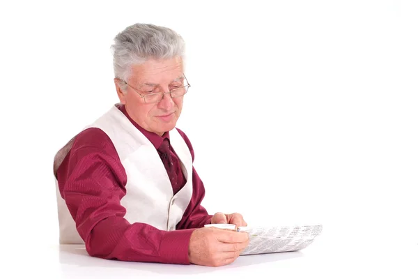 Handsome caucasian male sits at a table with a newspaper — Stock Photo, Image