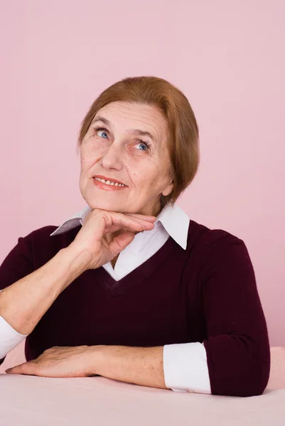 Pretty elderly Caucasian business woman sits dreaming — Stock Photo, Image