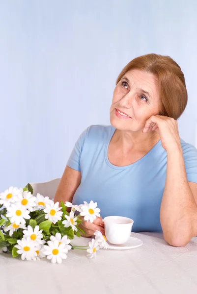 Seniorin am Tisch — Stockfoto