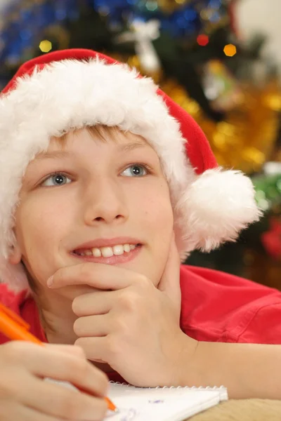 Хлопчик у капелюсі Санта написання — стокове фото