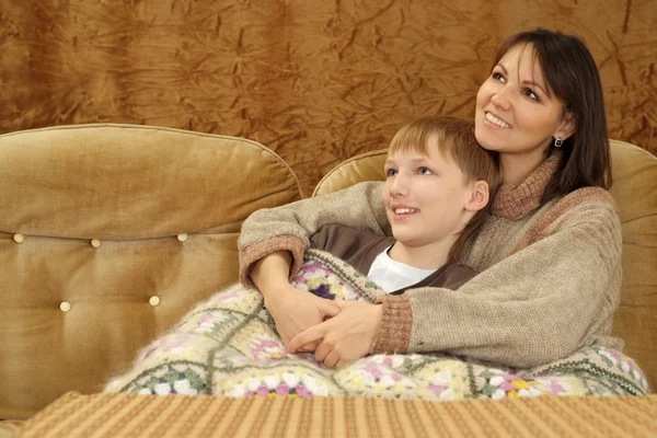 漂亮的白种人母亲与她的儿子坐在沙发上 — 图库照片