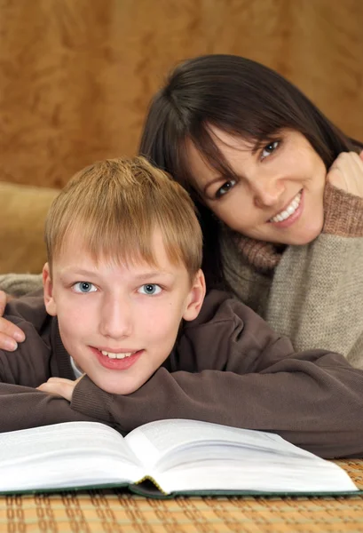 Vackra bra kaukasiska mamma med sin son läser en bok — Stockfoto