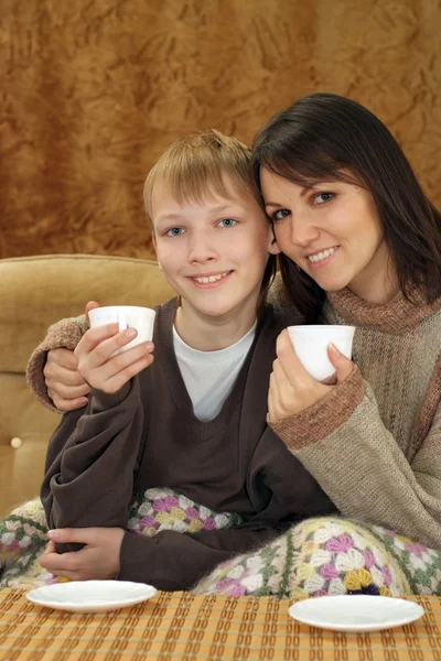 Kaukasiska mamma med sin son som sitter i soffan — Stockfoto