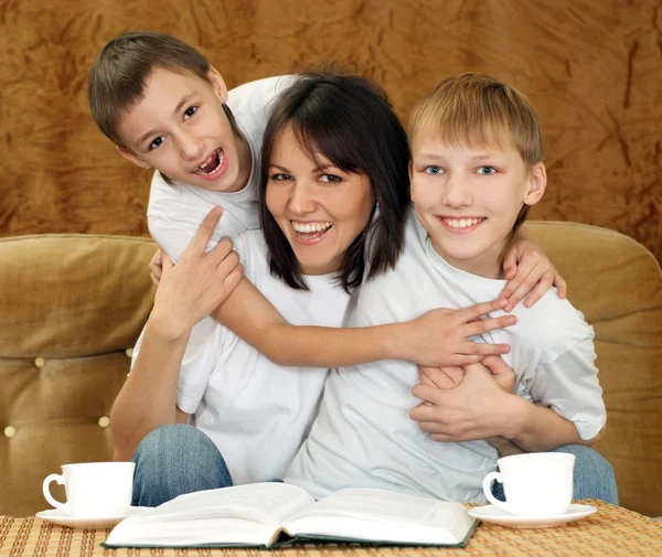 Mooi charmante moeder en zonen zitten — Stockfoto