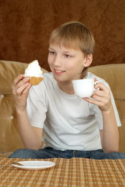 Lindo menino feliz sentado a uma mesa — Fotografia de Stock