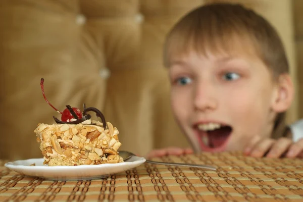 Hermoso buen muchacho sentado en una mesa — Foto de Stock