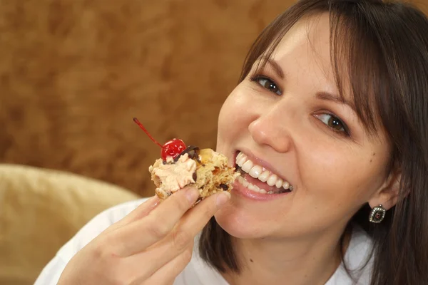 Beautiful woman sitting at a table with a cake — Stock Photo, Image