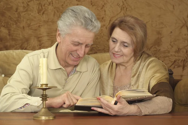 Beautiful Caucasian elderly couple sitting at a table — Stock Photo, Image