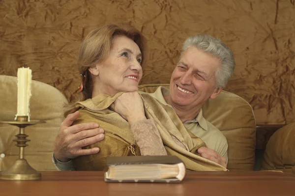 Luck Caucasian elderly couple sitting at a table — Stock Photo, Image