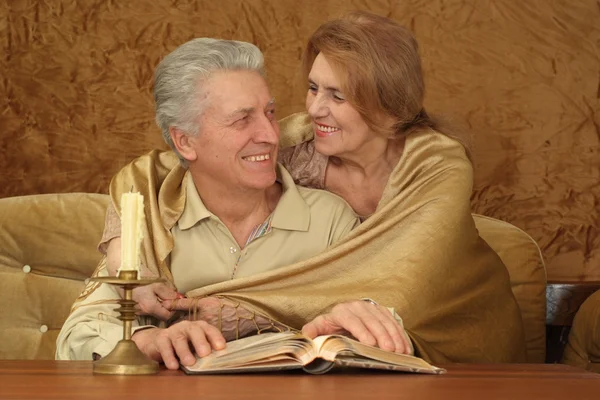 Beautiful elderly couple sitting at a table — Stok fotoğraf