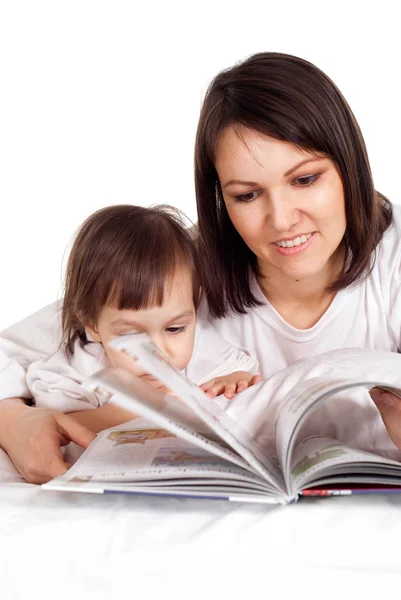 Una buena mamá caucásica con su hija acostada con un libro —  Fotos de Stock