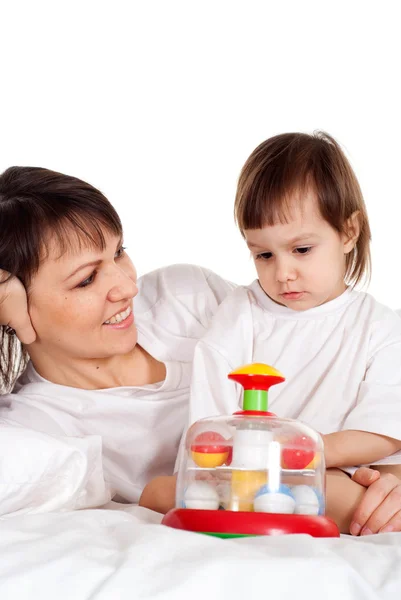 En vacker mor med dottern leker med en leksak — Stockfoto