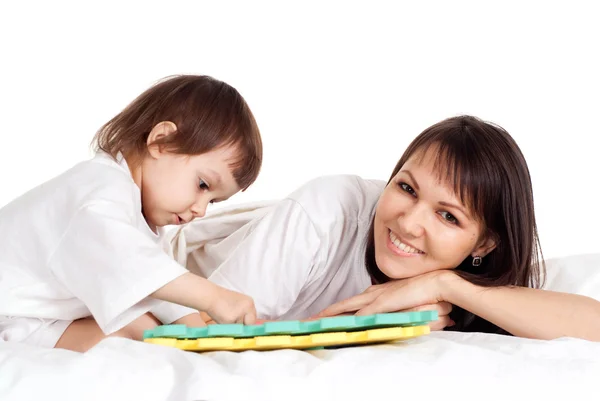 Een mooie mama met haar dochter spelen met een mat — Stockfoto